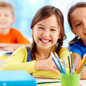 kinder sitzen im klassenzimmer und lächeln in die kamera